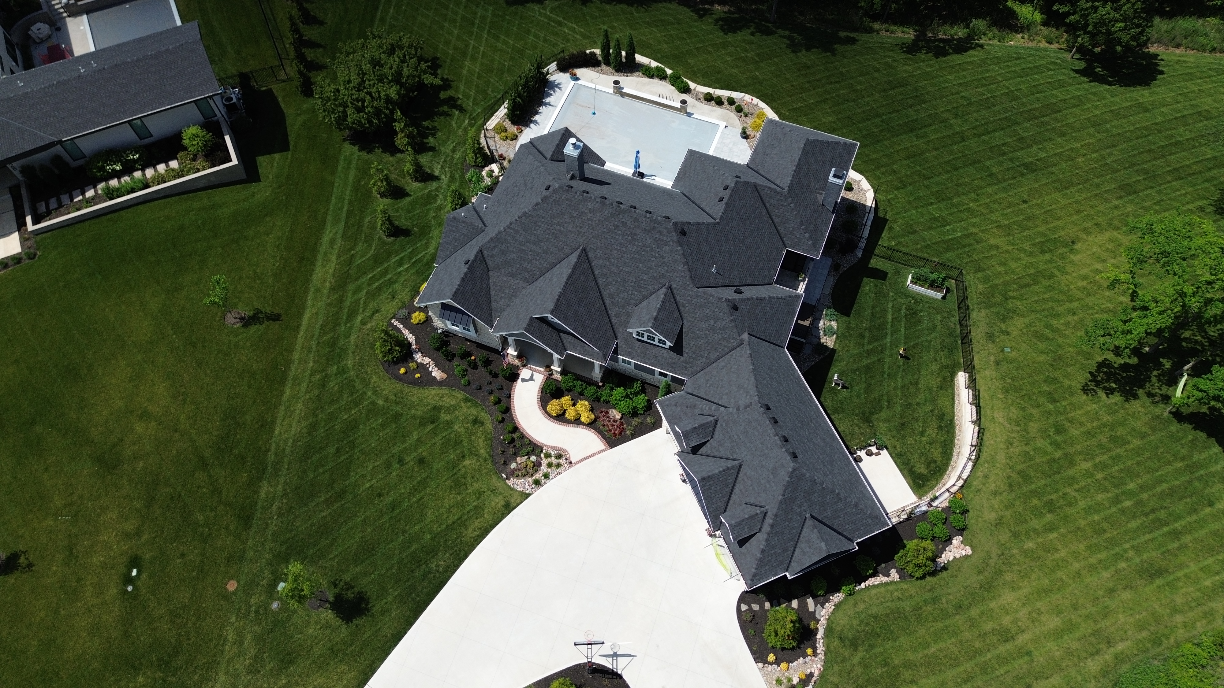 Aerial drone shot of a large Wisconsin luxury home with new dark shingle roof