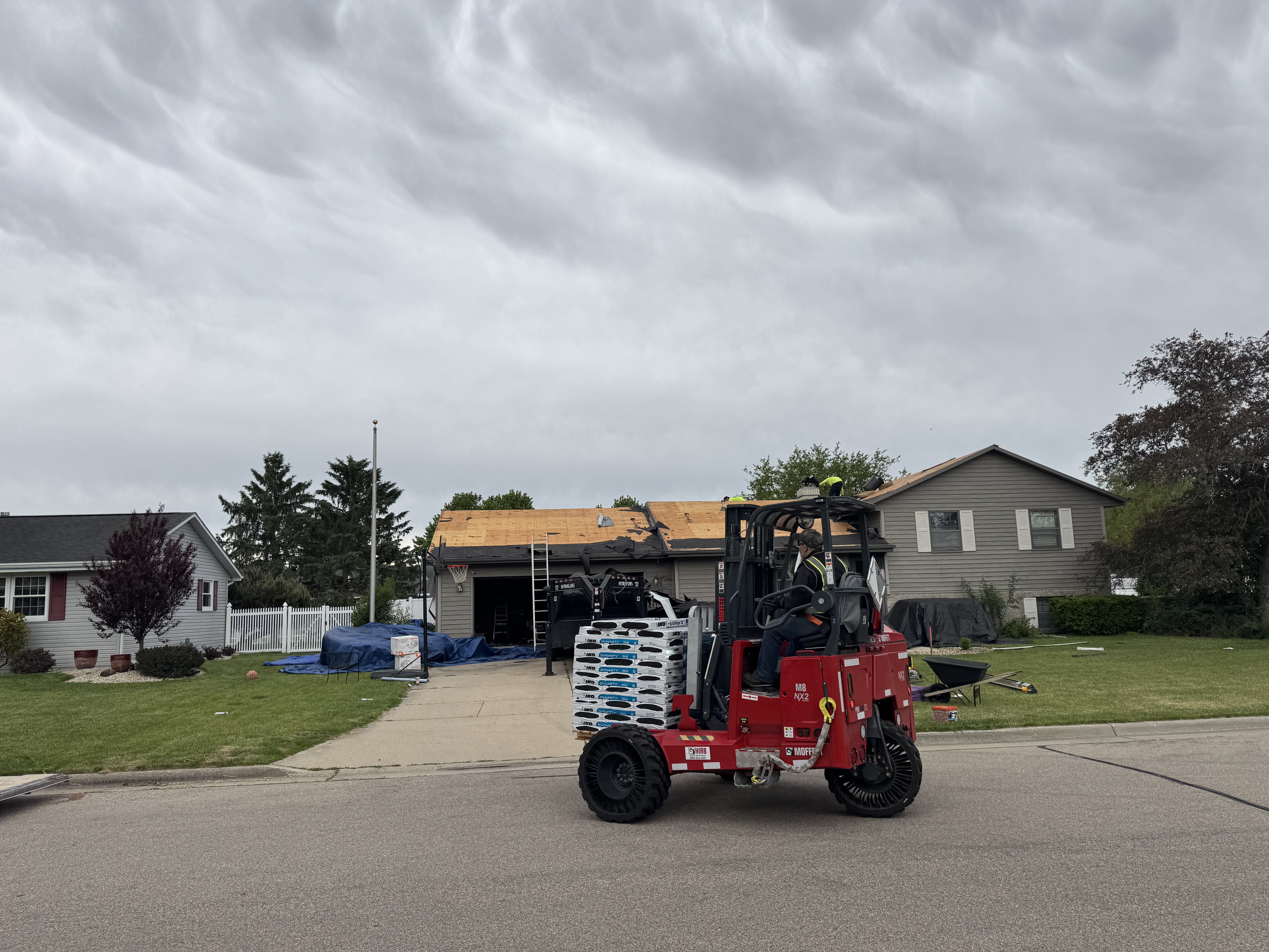 Forklift staging shingle pallets at a Pixler mid tear off job site