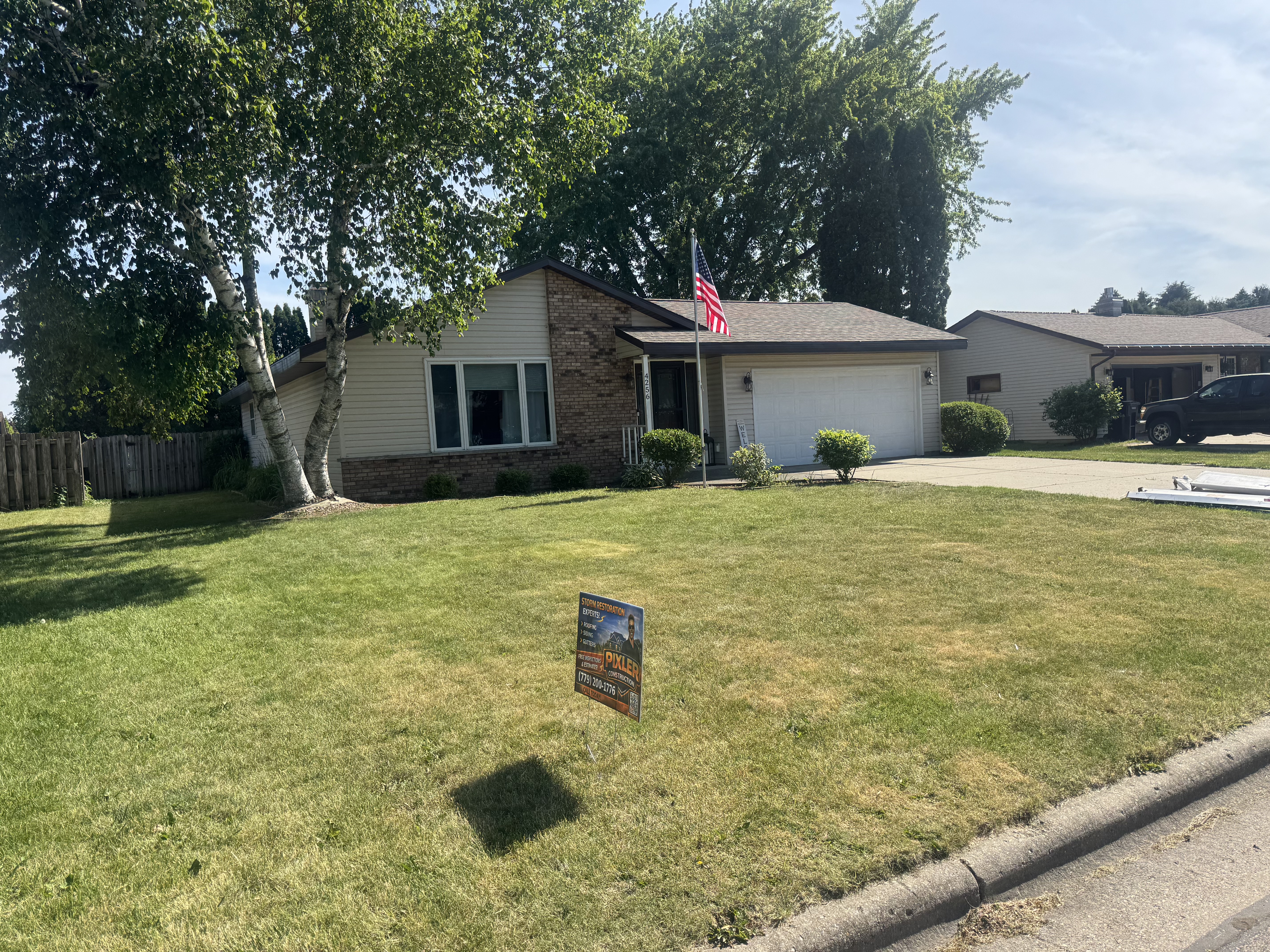 Wisconsin ranch home with a finished Pixler roof and American flag out front